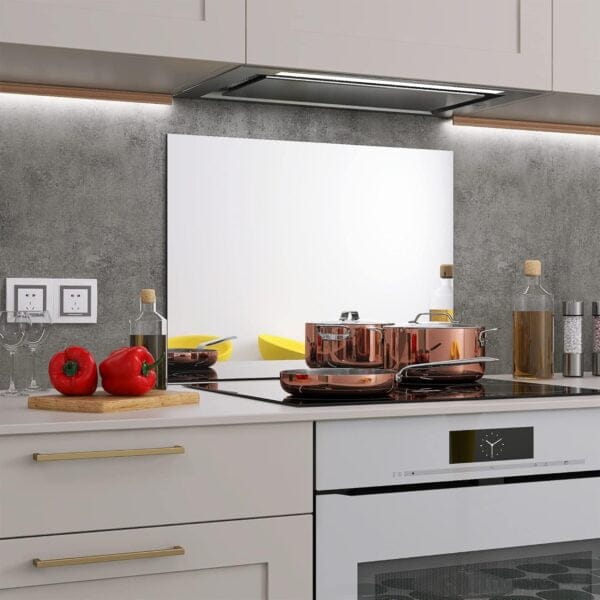 A stylish kitchen setup with the BELOFAY glass mirror splashback installed, reflecting light and providing easy-to-clean protection behind the stove.